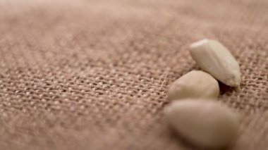 Çiğ badem fıstığı kabarık bir çuval bezin üzerine ağır çekimde düşüyor. Sağlıklı sağlıklı beslenme malzemesi