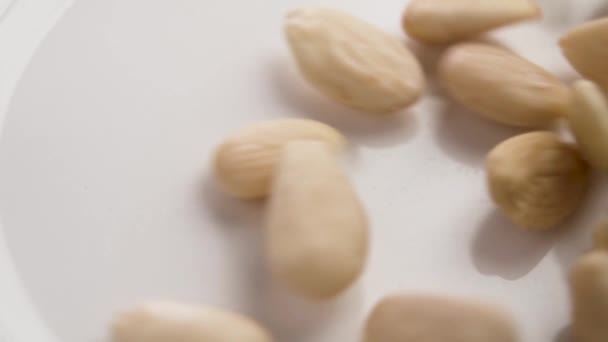 杏仁壳在白色陶瓷表面缓慢下落 靠近点 — 图库视频影像