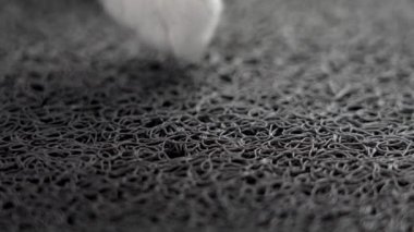 Yumuşak bir minder üzerinde yürüyen bir kedi. Lastik lifler kapanıyor.