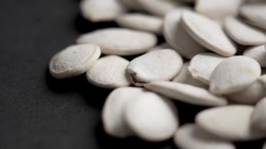 Siyah üzerine kızarmış balkabağı çekirdeği yakın plan. Döndürme.