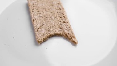 Kırıntılı beyaz bir tabakta karabuğday gevreği. Diyet açlık konsepti. Döndürme