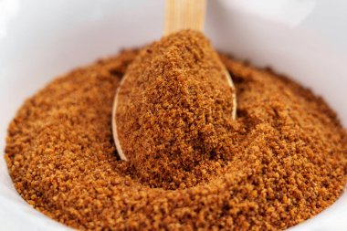 Bir yığın kahverengi hindistan cevizi şekeri ve bir çay kaşığı dolusu granüller.