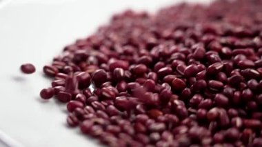 Beyaz seramik bir kapta kırmızı fasulye ya da adzuki taneleri. Döndürme