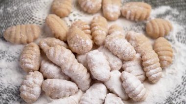 Mini pişmemiş İtalyan patatesli gnocchi unu yavaş çekimde yavaşça düşüyor. Döndürme