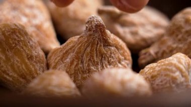 Şefin eli kurutulmuş inciri yakından alır. Kuru meyveler. Döndürme