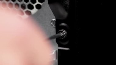 Masaüstü bilgisayar bloğunun arka kapağındaki vidayı sökmek. Bilgisayar bakımı. Makro