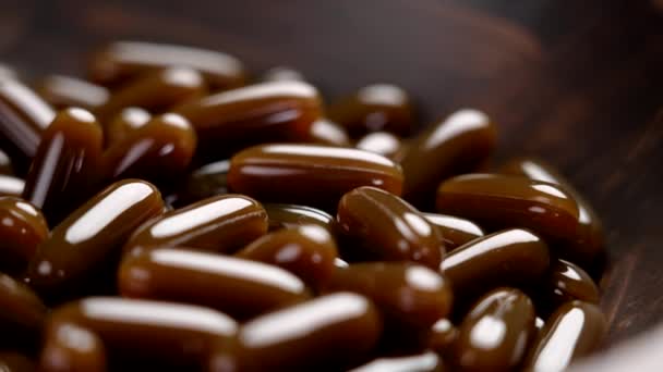 向日葵卵磷脂棕色软胶药丸在黑暗的木制碗里 营养营养补充剂 — 图库视频影像