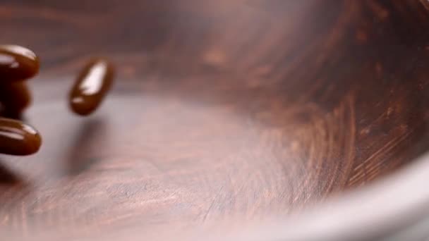 卵磷脂补充软胶囊掉进黑暗的木制碗里 棕色营养药丸 — 图库视频影像