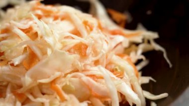 Tahta kasede doğranmış havuçla mayalanmış lahana turşusu ve ekşi beyaz lahana. Döndürme