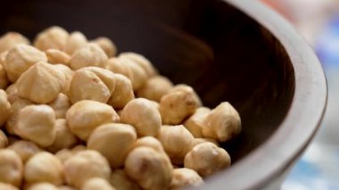 Ahşap bir mutfak kasesinde kabuğu soyulmuş fındık çekirdeği. Kabuklu fileto. Döndürme