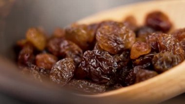 Kuru üzümlü kuru üzüm ve ahşap tencere. Makro atış. Döndürme