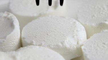 Çelik çatalla yumuşak keçi peyniri yemek. Geleneksel süt ürünü. Makro çekim