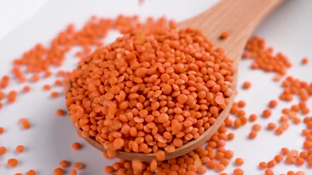 生有机红豆的木制勺子 高蛋白谷类产品 慢动作地撒上未煮熟的橙子 — 图库视频影像