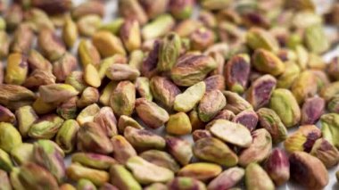 Ağır çekimde düşen soyulmuş fıstıklı fındıklar. Kabuksuz çekirdekler. Sağlıklı besin malzemesi yakından geliyor. Döndürme