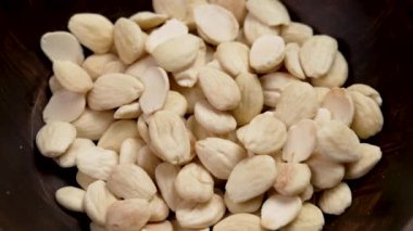 Çiğ kabuklu badem. Kırsal bir kasede soyulan fındıklar. Döndürme
