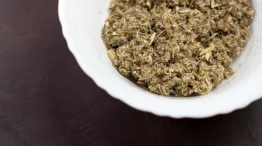Kurutulmuş pelin otu ya da seramik kasede bulunan şifalı ot. Alternatif ayurvedik ilaç bileşeni. Döndürme