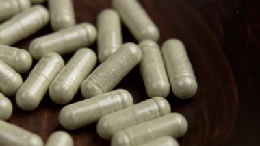 Tahta bir doğal kasede antidepresan bitkisel tedavi kapsülleri. Alternatif tıp konsepti. Vitamin kompleksi. Döndürme