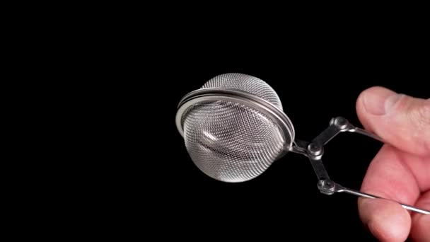 茶水滤清器放在黑色背景上 金属球状药草注射器关闭 厨房用具 — 图库视频影像