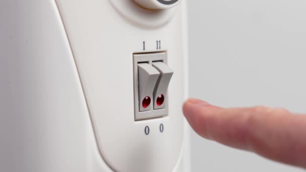 部屋の快適さのための温度を高める赤いライトが付いているプラスチック ボタンを押す電気暖房ラジエーターの手の切り替え — ストック動画