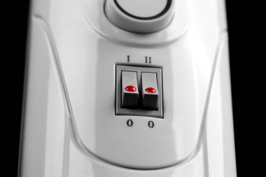 Kontrol paneli kapalı ev elektrikli yağ ısıtıcısı. Anahtarları ve ayarlanabilir düğmesi olan yerli ısıtma radyatörü
