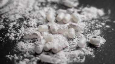 Kırık tıbbi kapsüllerin üzerine beyaz toz dökülüyor. Uyuşturucu bağımlılığı kavramı