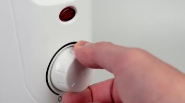 Elektrik konvektör radyatörünün ısısını ayarlıyorum. Kırmızı ısıtma sinyali yanıyor. Kış konseptinde evde elektrik tüketimi