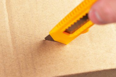 Paketi açıyorum. Karton paketi bıçak ile açıyorum. Kahverengi kraft kağıdı kesiliyor. Yakın plan.