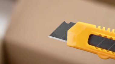 Alet bıçağı ya da maket bıçağı, paketin açılması için geri çekilebilir kesiciyle birlikte.