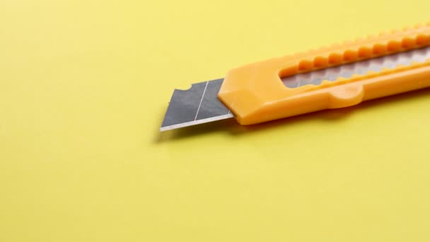 Užitný Nůž Zasouvací Segmentovou Čepelí Kreativním Žlutém Pozadí Zblízka Kancelářský — Stock video
