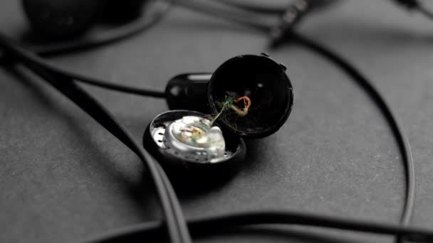 黑色耳机坏了 背景是深灰色的 被砸坏的耳机便宜而有问题的电子设备概念 — 图库视频影像