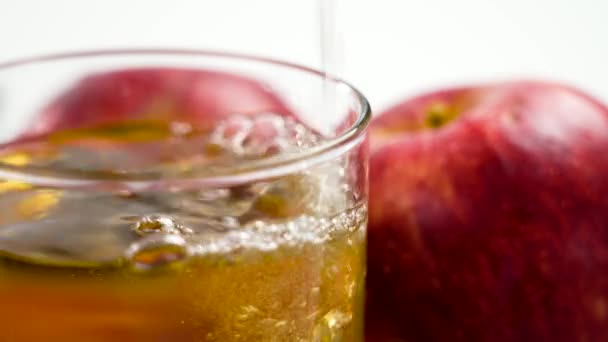 リンゴサイダーをテーブルの上のグラスに注ぎ ジューシーな赤いリンゴを閉じます 伝統的なスペインの軽いアルコール飲料 — ストック動画