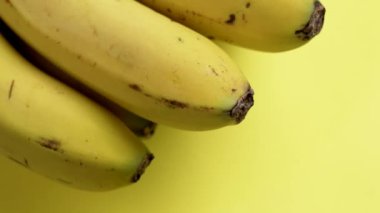 Yaratıcı bir arka planda bir grup olgun sarı muz. Döndürme. Makro atış. Sağlıklı yaşam tarzı kavramı