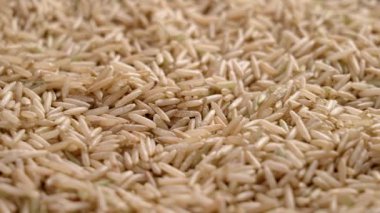 Bir yığın çiğ beyaz Basmati pirinci. Cilalanmamış tohumlar. Asya mutfağı malzemesi. Makro atış. Döndürme