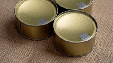 Üç kapalı alüminyum teneke kutu konserve ton balığı ve kırsal çuval bezi. Döndürme