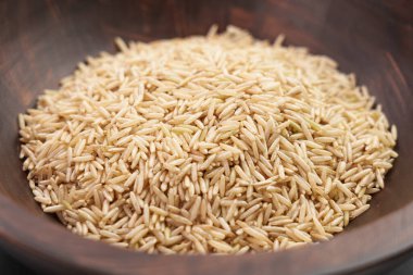 Kahverengi ahşap kasede işlenmemiş basmati pilavı yakın plan. Sağlıklı organik bileşenler