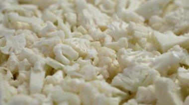 Küçük, sulu sebze parçalarıyla doğranmış çiğ Karnabahar. Döndürme