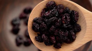 Tahta kaşıkta kuru kiraz. Yaklaş. Besleyici buruşuk kurumuş böğürtlen. Sağlıklı susuz kalmış vitamin bileşeni. Üst görünüm