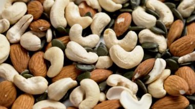 Ceviz bolluğu, kaju, badem ve kabak çekirdekleri. Sağlıklı besleyici bileşenler. Döndürme