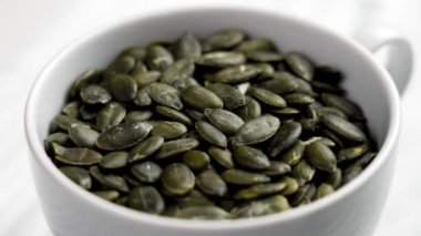 Dolu beyaz seramik kabak çekirdeği kabuğu kabuğu tohumu. Sağlıklı ham maddeler. Döndürme