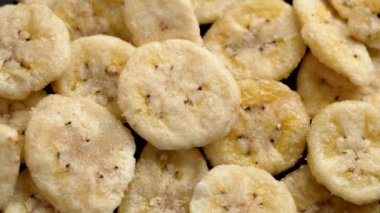 Kurutulmuş muzların üst görüntüsü. Çıtır çıtır kuru meyveli cipsler kapanıyor. Döndürme