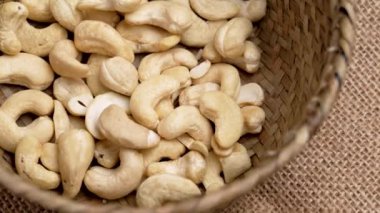 Kırsal ahşap bir örgü kasesinde organik kaju fıstığı var. Besleyici besin maddeleri. Kırsal bakış açısı. Döndürme