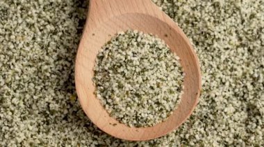 Kırsal ahşap kaşıkta kenevir tohumu yakın çekim. Soyulmuş besleyici kenevir sativa taneleri. Süper yemek malzemesi. Döndürme
