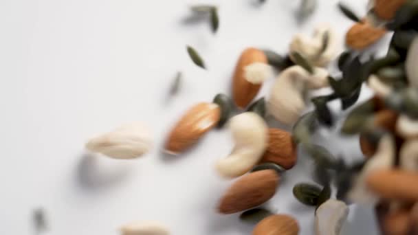 異なるナッツを混ぜる カシュー アーモンド カボチャの種子を混ぜる 健康的な栄養成分が近づいています スローモーション — ストック動画