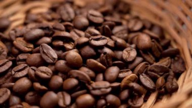 Kavrulmuş kahverengi kahve çekirdekleri ve rattan rustik kabı yakın plan. Kaliteli kokulu içecek malzemesi. Döndürme