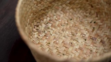 Çiğ kenevir taneleri (kenevir sativa tohumları) yavaş çekimde kırsal bir hasır sepete düşüyor. Sağlıklı gıda takviyeleri kapanıyor.