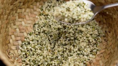 Çiğ kenevir taneleri (kenevir sativa tohumları) kırsal hasır sepetinde. Sağlıklı gıda takviyesi.