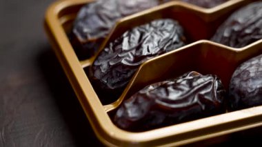 Kurumuş medikal jool altın sarısı paketlerde kahverengi bir tahta üzerinde yakın plan çekimde. Arap tatlı ikramı. Döndürme