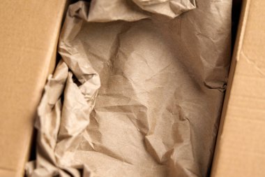 Karton kutu ve buruşuk kahverengi kağıt dolgu malzemesi paketlenmeye hazır. Boş teslimat konteynırı. 