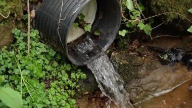 Kara kanalizasyon borusundan akan endüstriyel kirlenmiş atık su yavaş çekimde nehre akıyor. Küresel ısınma kavramı