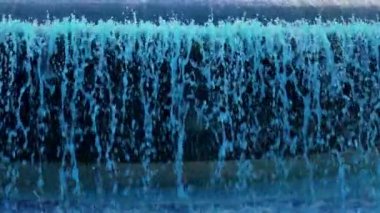 Avrupa 'da yavaş çekimde bir tatil çeşmesinin renkli mavi suları dökülüyor.